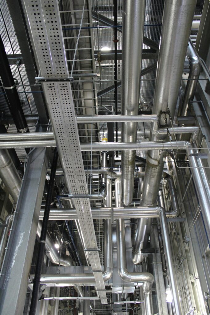 Vertical shot of steel pipes and ventilation in an industrial setting.