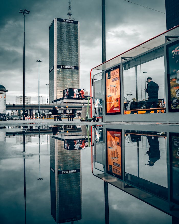 Reflective urban scene of Warsaw with tall building and cloudy sky. Captivating city life.